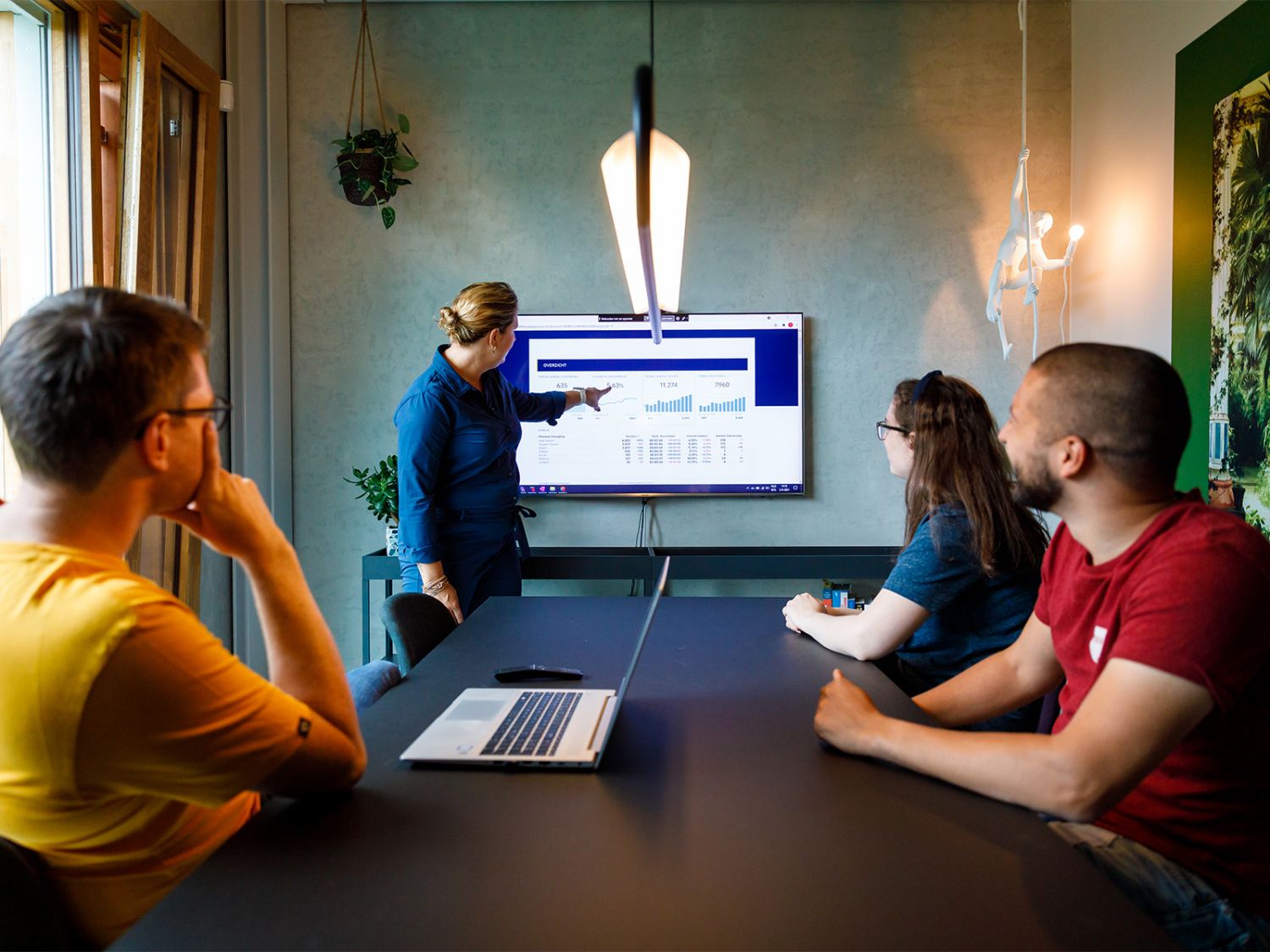 Pier, Sean en Chanine van eResults bekijken een presentatie van Monique